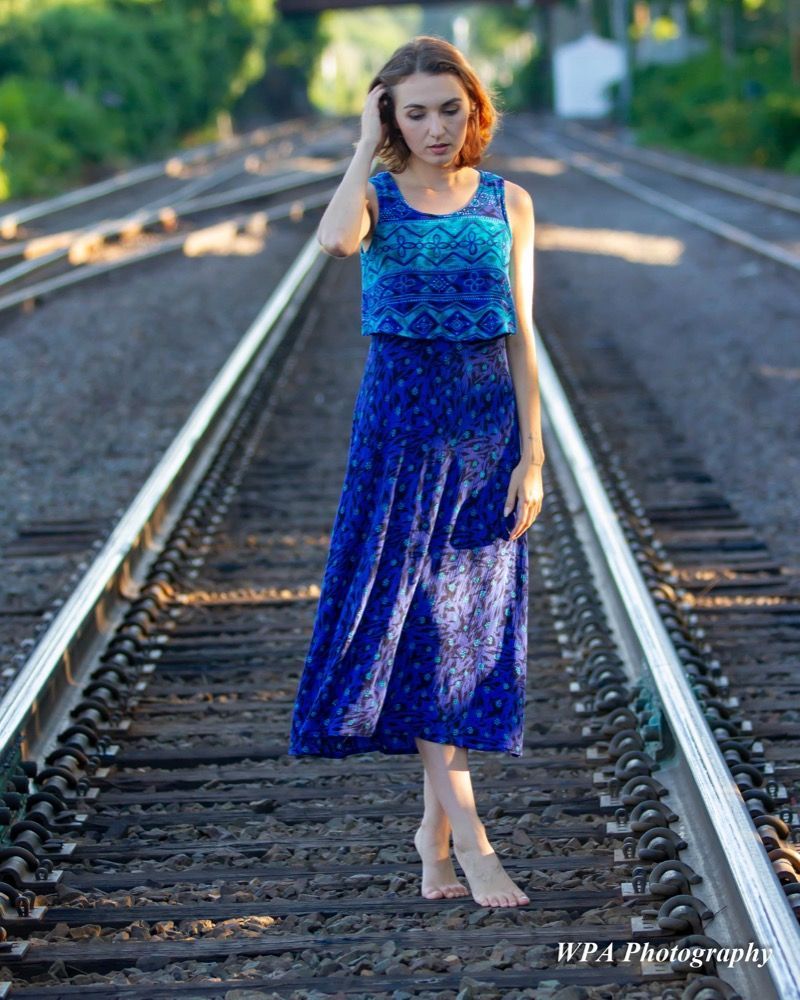 Portrait photograph of woman on train tracks