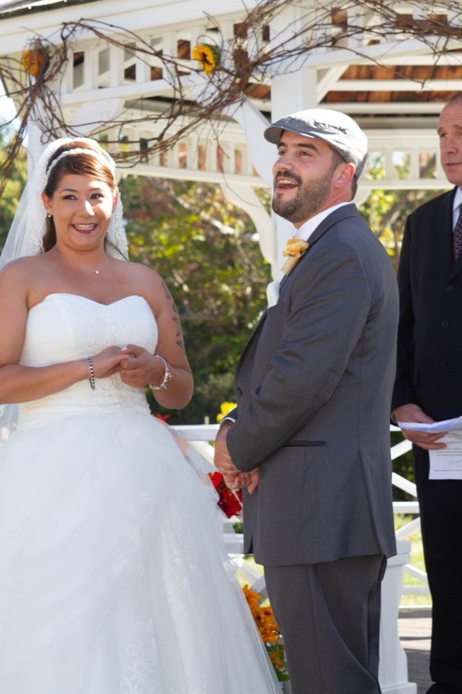 Photo of bride and groom smiling at altar