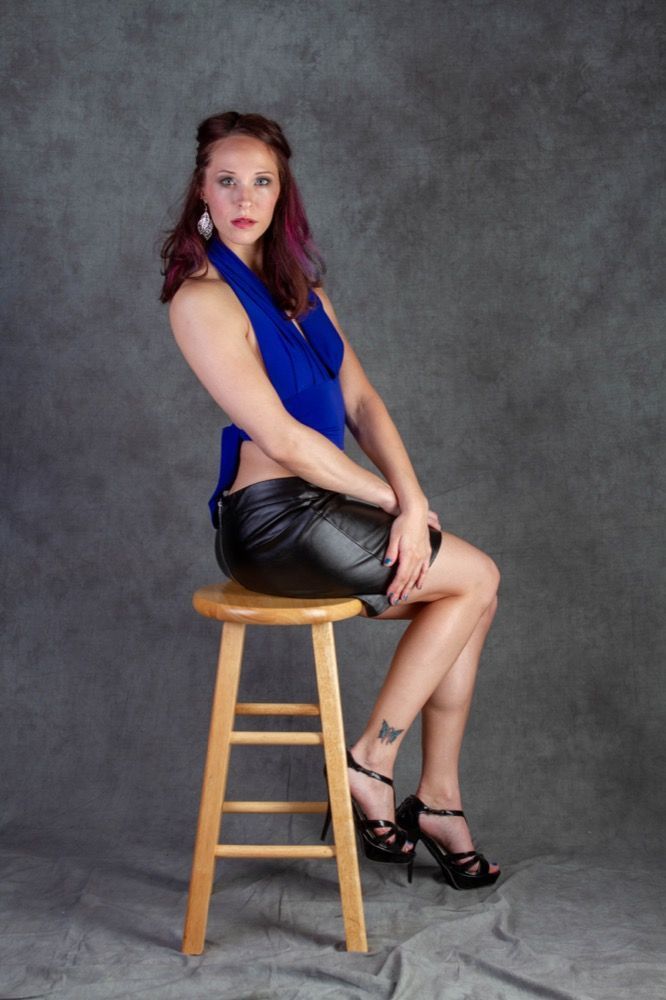 Portrait photograph of woman sitting on stool