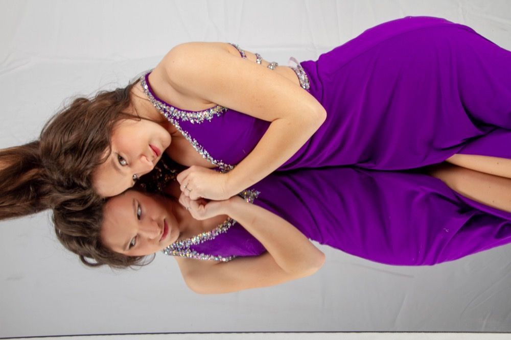 Portrait photograph of woman in purple dress